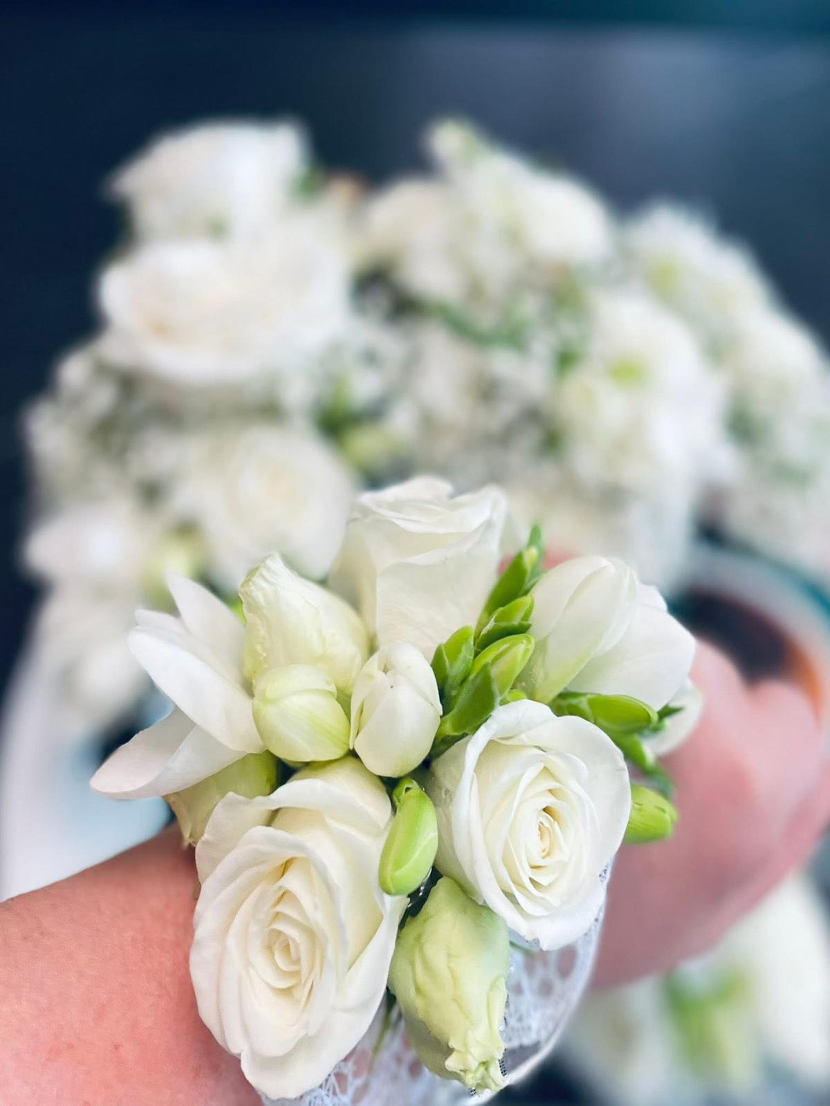 Brățară albă elegantă de mireasă pe încheietură cu trandafiri albi mari, freziile albe și lalele, prinse cu dantelă albă fină – Florăria Iedera Jibou