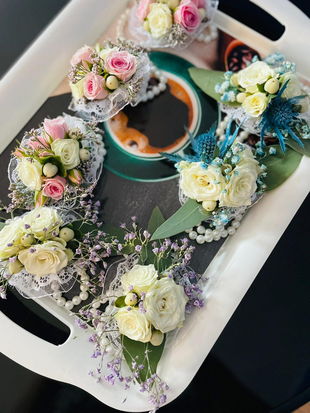 Set variat de cocarde și brățări de nuntă în paletă mix roz, alb, fucsia, bleu cu eryngium, mov și auriu, aranjate pe tavă – Florăria Iedera Jibou