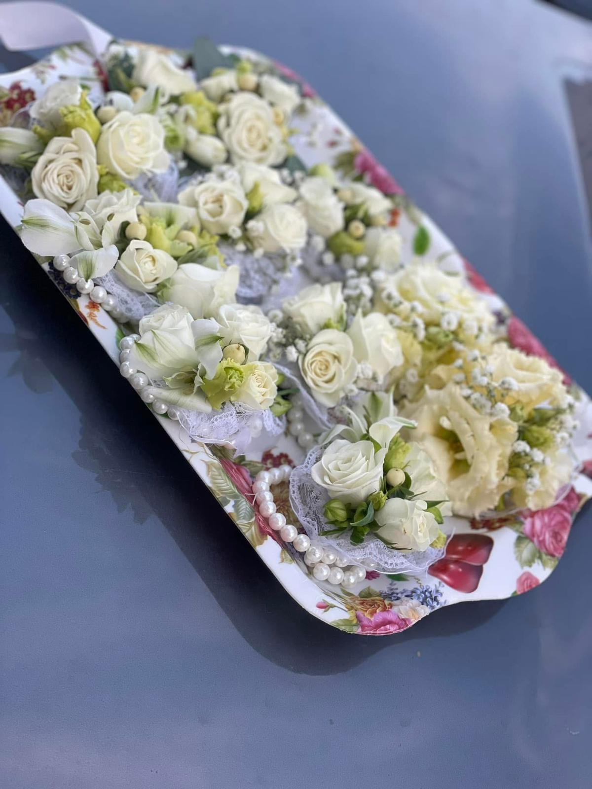 Set extins cocarde nuntă albe și crem cu trandafiri albi, eustoma, hipericum verde și perle pe bandă de dantelă, aranjate pe tavă vintage – Florăria Iedera Jibou